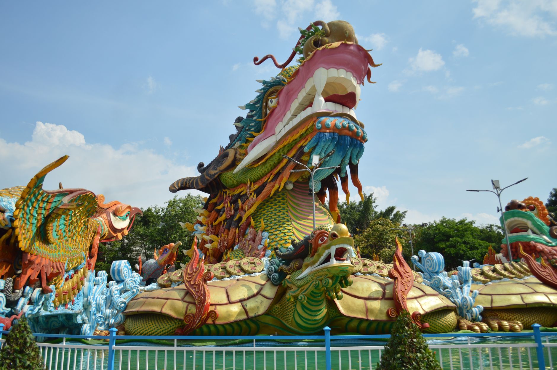 Patung naga yang semarak di taman terbuka, menampilkan detail yang rumit dan warna-warna cerah.