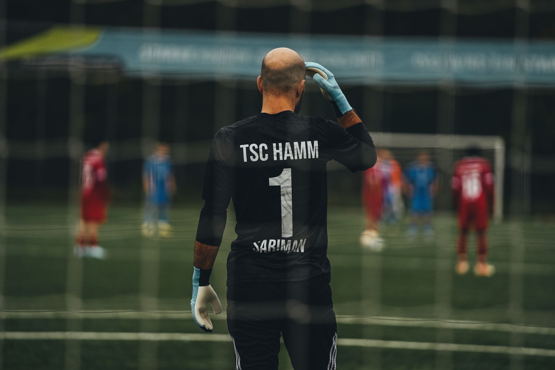 Seorang penjaga gawang sepak bola berdiri siap untuk melakukan tendangan penalti di lapangan.