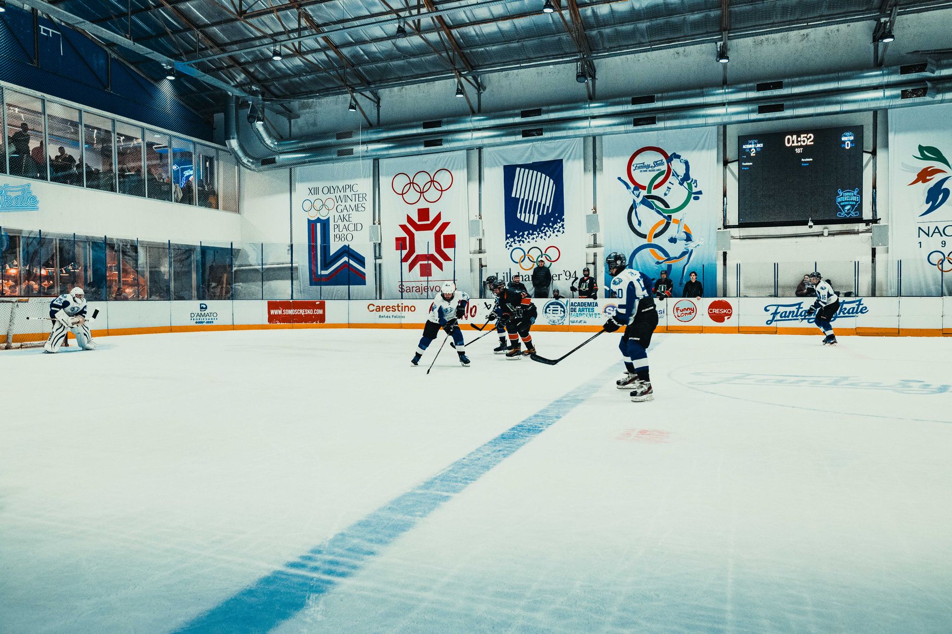 Permainan hoki es yang dinamis ditangkap di arena dalam ruangan dengan dekorasi Olimpiade di Buenos Aires, Argentina.