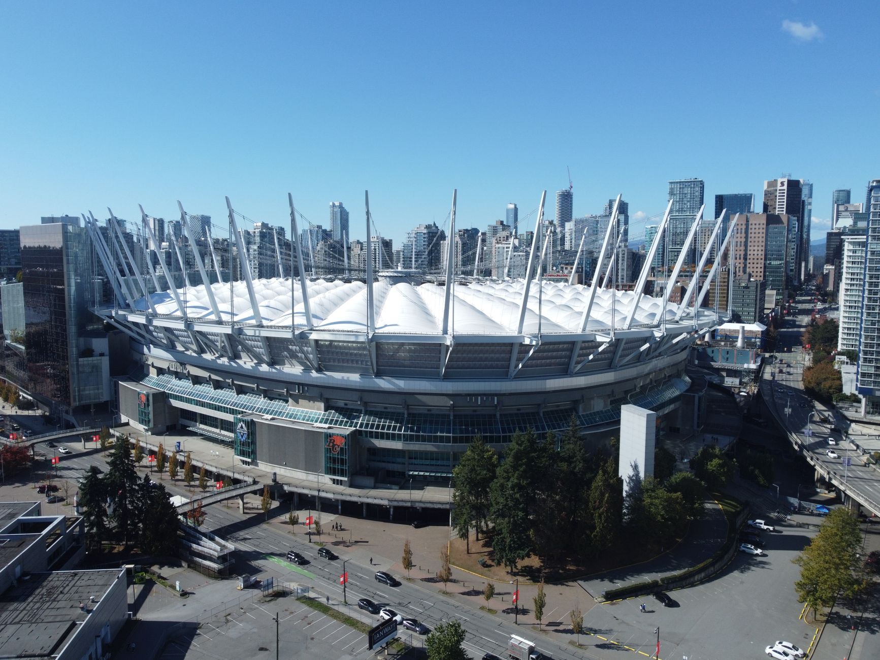 Pengambilan gambar udara Stadion BC Place di Vancouver dengan latar belakang pemandangan kota, memamerkan arsitektur modern.