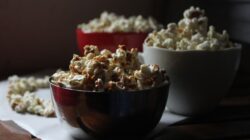 Kabar Terbaru: Tak Cuma Nonton Bareng Timnas Indonesia, Fans Garuda juga Bawa Pulang Hadiah 2 Pemandangan nyaman dengan popcorn dalam mangkuk di atas meja kayu, sempurna untuk suasana malam menonton film.