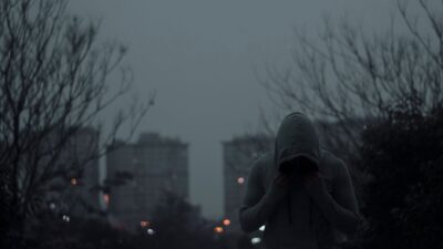 Sorotan: 3 Kunci Timnas Indonesia untuk Menundukkan Singapura di FIFA ASEAN Cup 2026: Amankan Tiga ... 8 Orang dengan hoodie abu-abu di lingkungan perkotaan yang kurang cahaya dengan suasana yang moody.