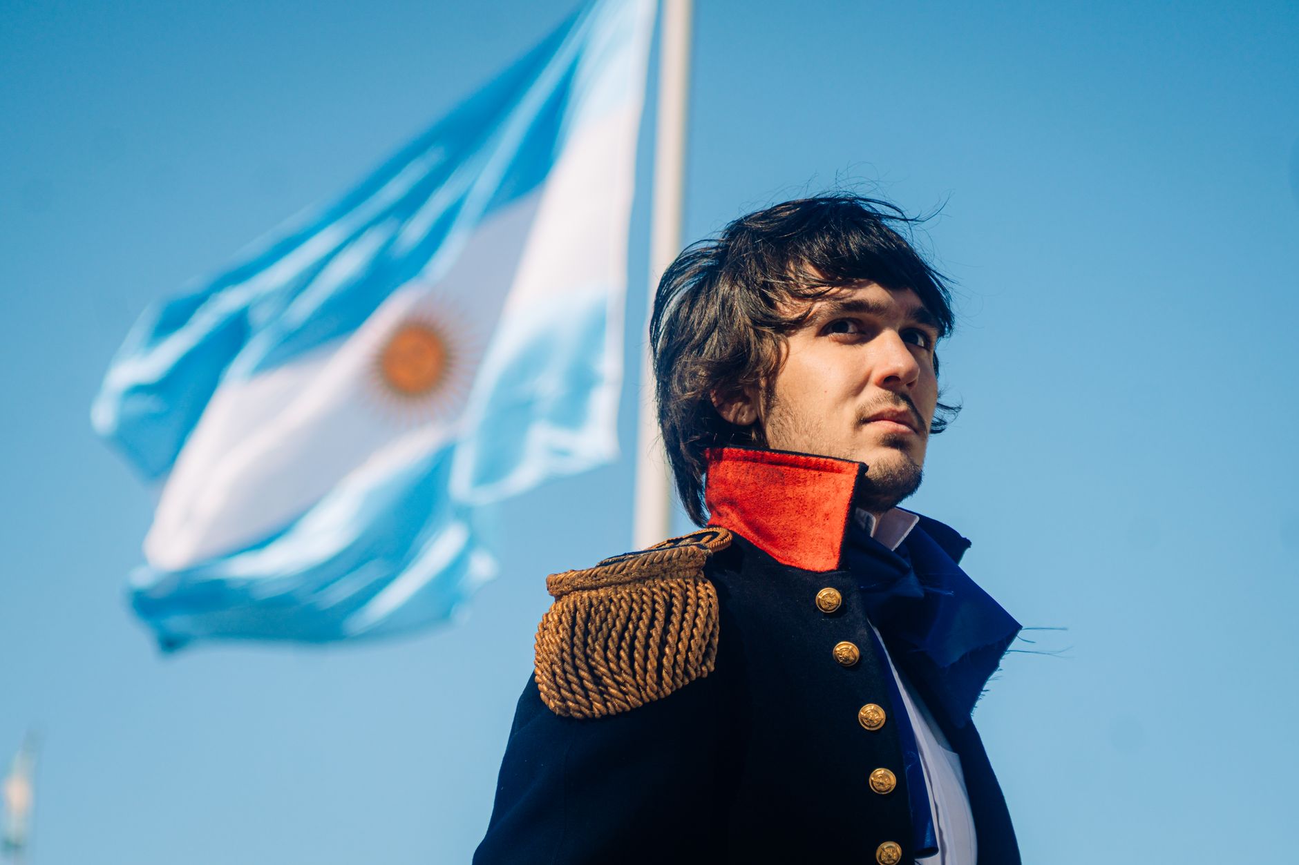 Potret dengan kostum sejarah di latar belakang bendera Argentina.