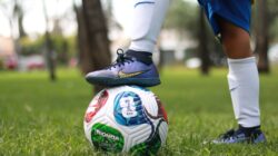 Update: Daftar 23 Pemain Timnas Bangladesh untuk FIFA ASEAN Cup 2026, Bek Andalan Absen karena Ced... 2 Seorang pemain sepak bola muda yang mengenakan kaus kaki putih berdiri di atas bola sepak warna-warni di luar ruangan.
