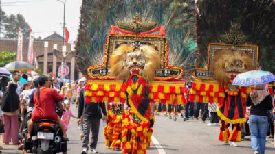 Parade jalanan meriah yang menampilkan tarian Reog Ponorogo yang semarak dan tradisional di Indonesia.