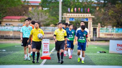 Tim sepak bola memasuki lapangan untuk Piala Terbuka Thạch Thất 2025 di Hà Nội, Vietnam.