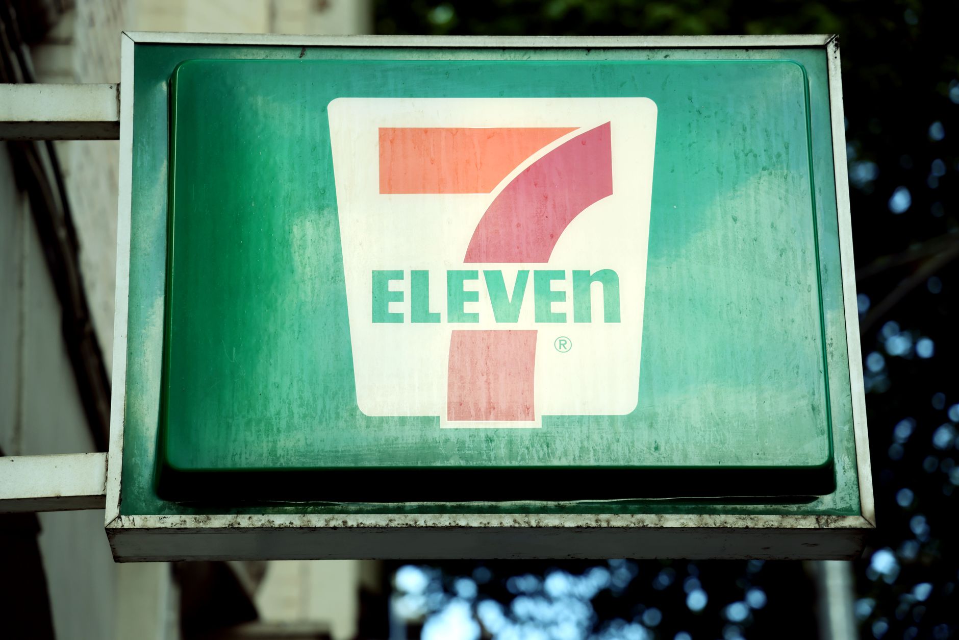 Tampilan dekat tanda toko 7-Eleven di lingkungan kota, di luar ruangan.