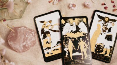 Kartu tarot bergaya dengan kristal kuarsa mawar pada latar belakang bertekstur, ideal untuk tema ramalan.