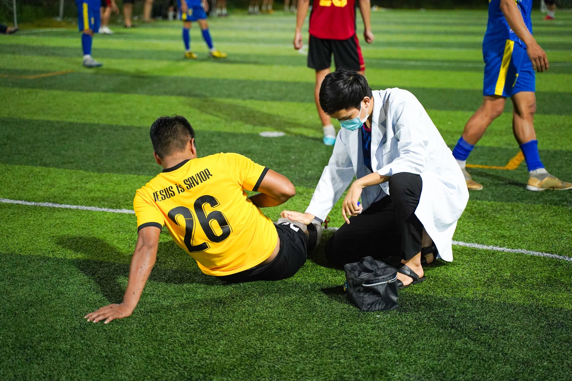Pemain sepak bola menerima pertolongan medis di lapangan karena cedera selama pertandingan.