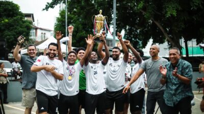 Sebuah tim sepak bola yang gembira merayakan kemenangan mereka dengan trofi di luar ruangan di Kota Panama.
