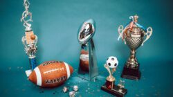 Kabar Terbaru: Kawinkan Gelar Juara Campus League Regional Yogyakarta 2026, Tim Putra dan Putri UNY Menat... 1 Koleksi trofi olahraga dan barang memorabilia yang mewakili pencapaian dan kesuksesan di latar belakang biru.