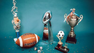 Kabar Terbaru: Kawinkan Gelar Juara Campus League Regional Yogyakarta 2026, Tim Putra dan Putri UNY Menat... 6 Koleksi trofi olahraga dan barang memorabilia yang mewakili pencapaian dan kesuksesan di latar belakang biru.