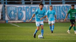 Pertandingan sepak bola yang menangkap pemain dalam aksi di lapangan, jersey yang cerah.