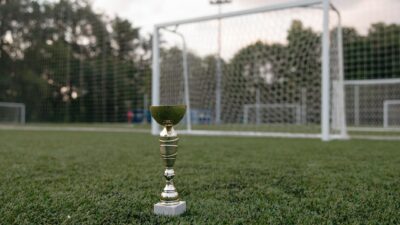 Kabar Terbaru: Sudah Sering Juara Piala AFF, Chanathip Songkrasin Tetap Berambisi Bawa Thailand Rebut Gel... 13 Trofi emas yang ditempatkan di rumput hijau dekat gawang sepak bola, melambangkan kemenangan.