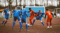 Sorotan: 4 Pemain Lokal Paling Gokil di Pekan ke-7 BRI Super League 2026/2027: Adam Alis, Rizky Rid... 2 Pertandingan sepak bola amatir yang intens antara tim biru dan merah di lapangan berlumpur.