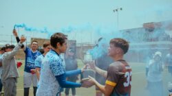 Sorotan: Catatan Beto Goncalves untuk Timnas Indonesia usai Juara FIFA ASEAN Cup 2026: Harus Lebih ... 2 Tim sepak bola merayakan kemenangan dengan trofi, dikelilingi asap biru di lapangan luar.