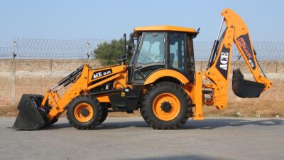 Backhoe loader ACE di lokasi konstruksi di Faridabad, India pada hari yang cerah.