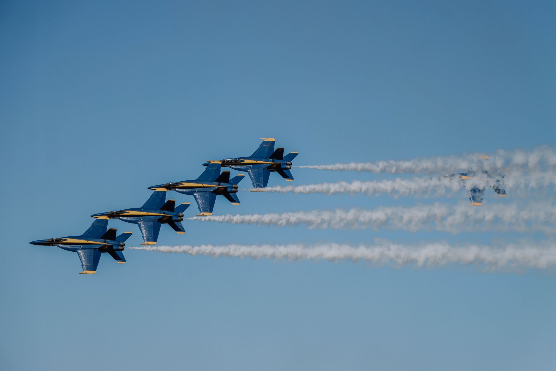 Jet Blue Angels melakukan formasi udara yang mengesankan di bawah langit biru yang cerah.
