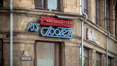 Pemandangan papan tanda PSS Społem dan Półudnie kuno di Jalan Świdnicka, Wrocław, menampilkan arsitektur bersejarah.