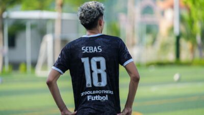 Sorotan: Theo Numberi Ceritakan Pengalaman Barunya di Garudayaksa FC yang tak Ia Dapatkan di Dewa U... 9 Tampilan belakang pemain sepak bola yang mengenakan jersey nomor 18 di hari yang cerah di luar ruangan.