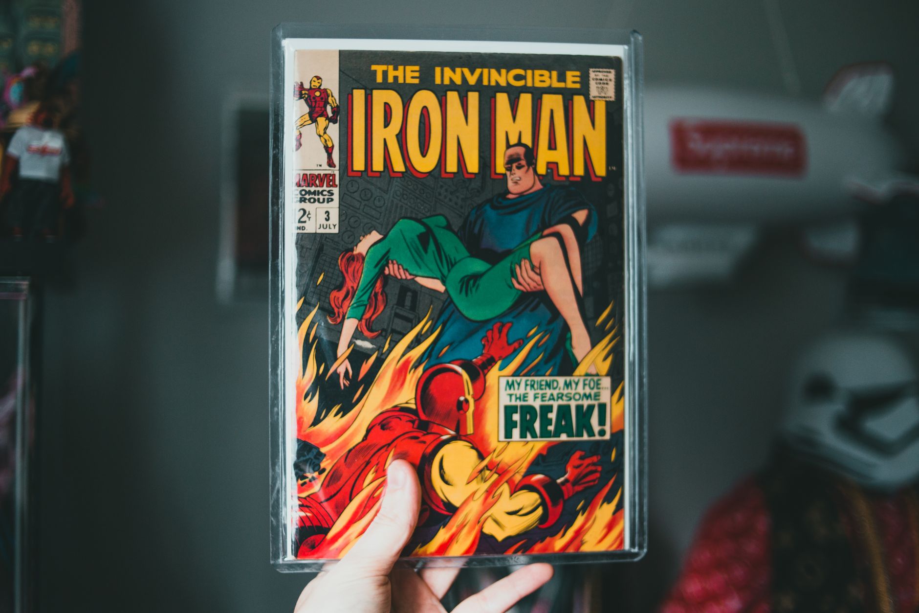 Buku komik Iron Man vintage dipegang di tangan, menampilkan gambar superhero ikonik.