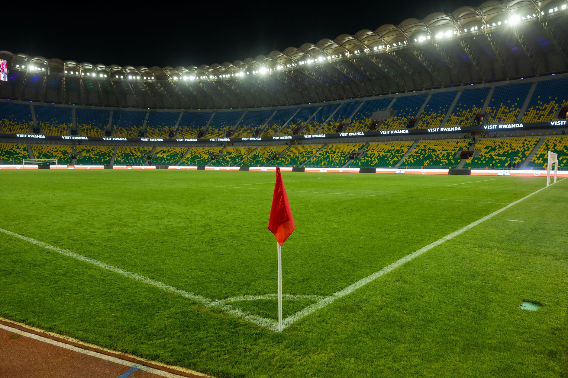 Jelajahi stadion bercahaya Kigali, yang memamerkan budaya olahraga Rwanda yang semarak, yang diambil pada malam hari.