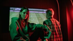Update: Link Live Streaming Final FIFA ASEAN Cup 2026: Timnas Indonesia Vs Thailand 6 Dua orang dewasa muda bermain video game dengan intens di dalam ruangan menggunakan pengontrol game.