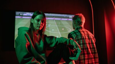 Update: Link Live Streaming Final FIFA ASEAN Cup 2026: Timnas Indonesia Vs Thailand 12 Dua orang dewasa muda bermain video game dengan intens di dalam ruangan menggunakan pengontrol game.