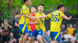 Sekelompok pemuda merayakan kemenangan sepak bola di luar ruangan di Hanoi.