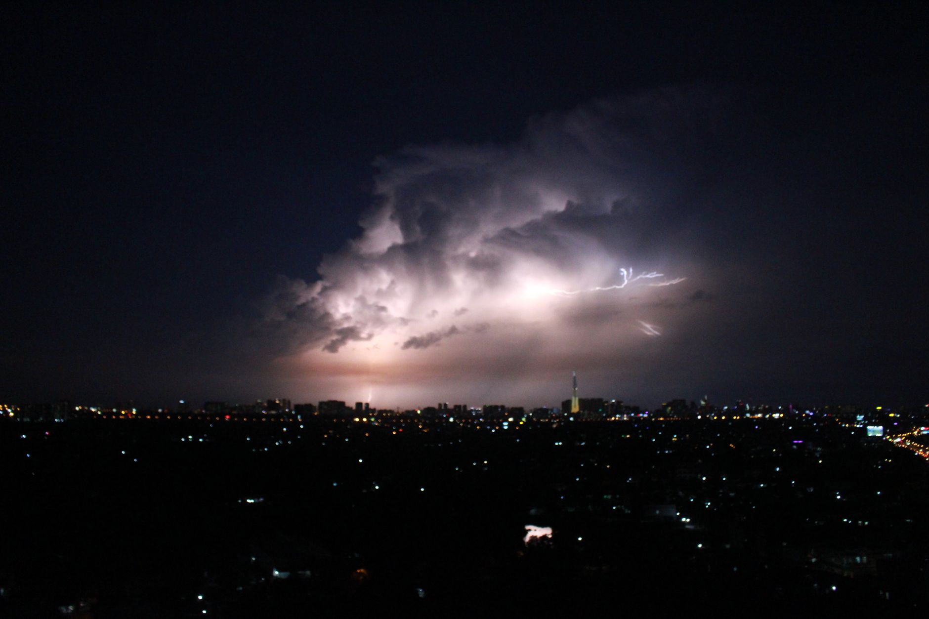 Pemandangan malam yang menakjubkan dari badai petir yang menerangi garis kota Ho Chi Minh.